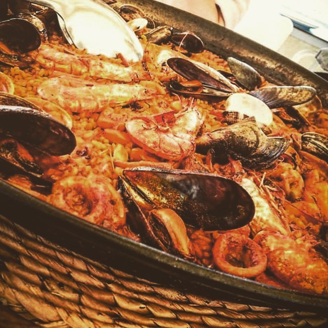 Paella de marisco de El Galeón con mejillones, langostinos y calamar en una paellera